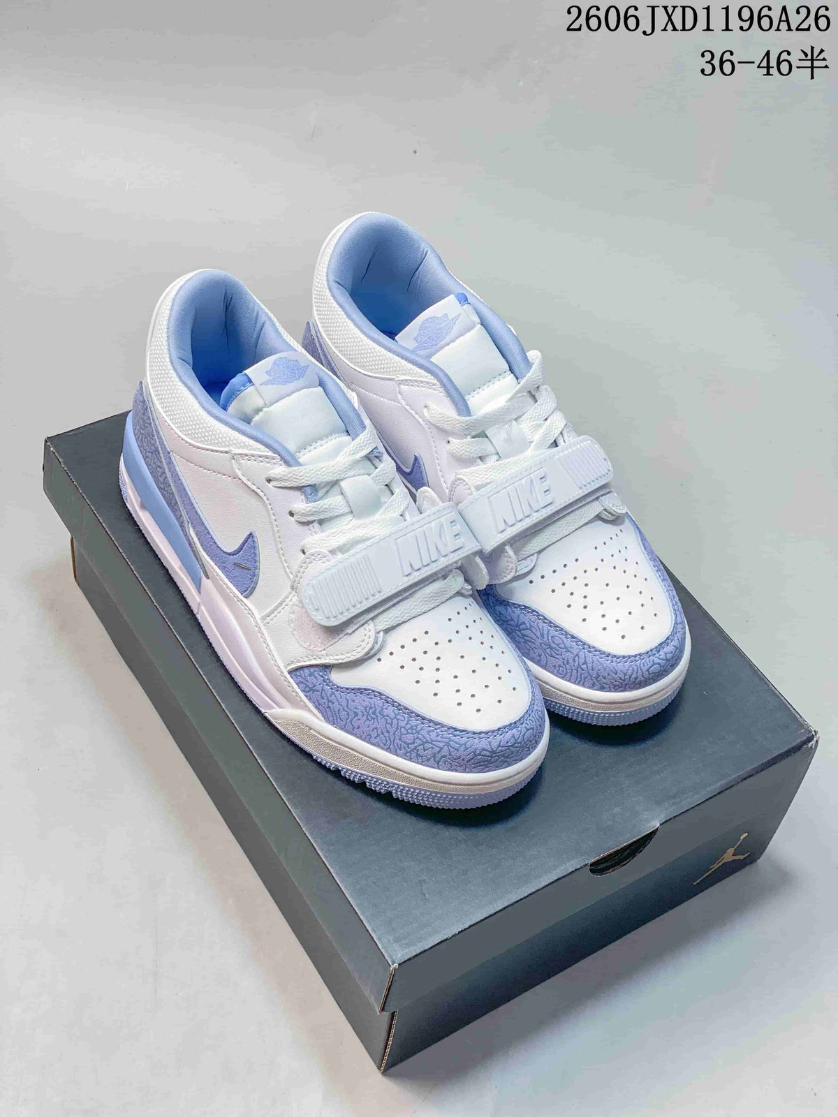 Pair of white and blue Air Jordan Legacy 312 Low sneakers shown on a shoebox