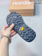 Close view of the rugged black outsole, showing a deep lug pattern and visible Vibram branding.