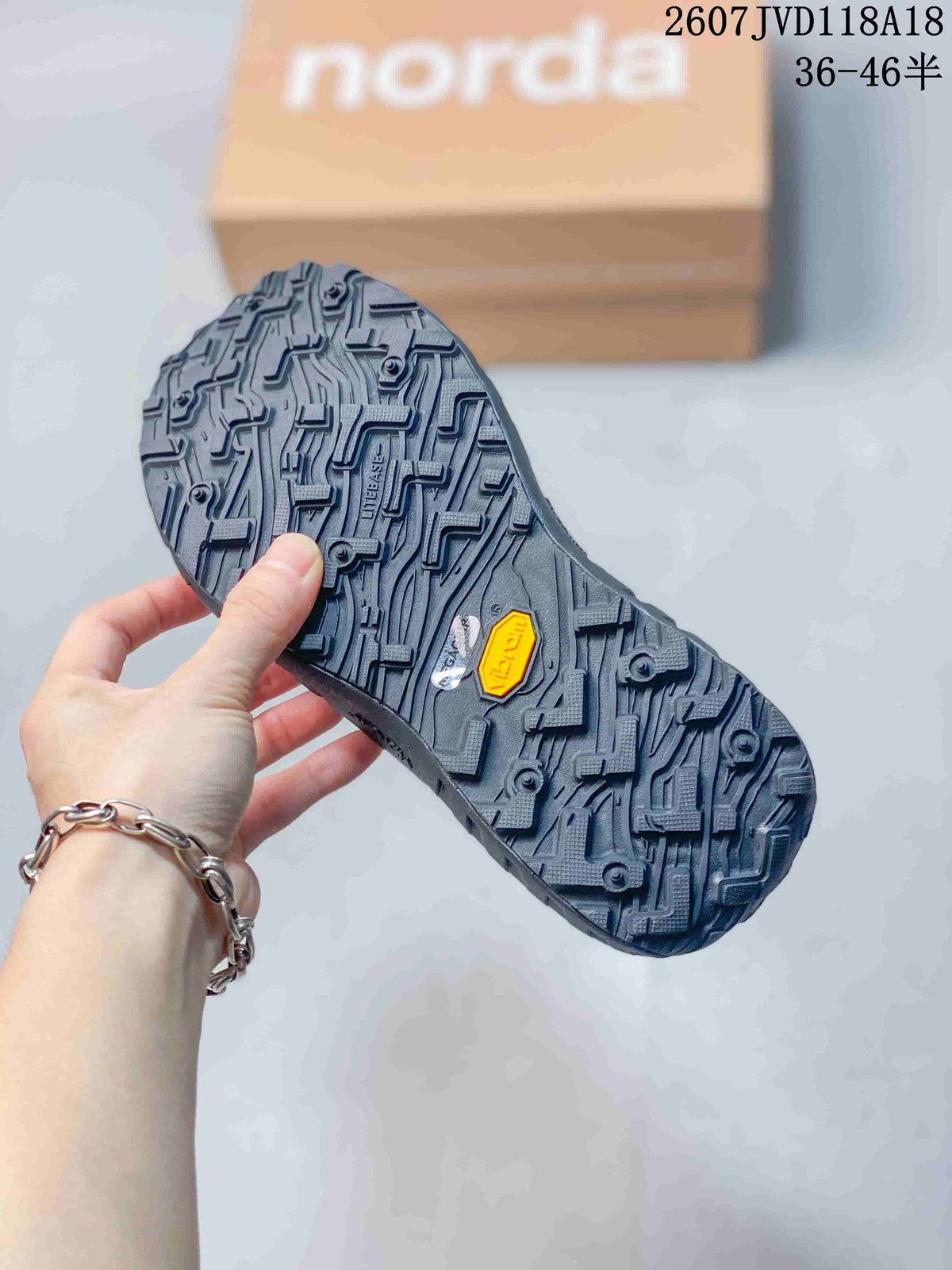 Close view of the rugged black outsole, showing a deep lug pattern and visible Vibram branding.