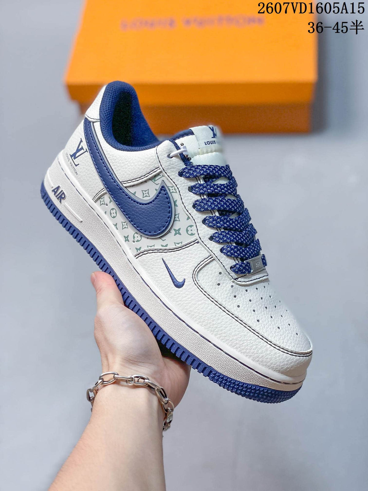 Close side view of a white and blue sneaker showing the patterned side panel, blue outsole, perforated toe box, and decorative side details.