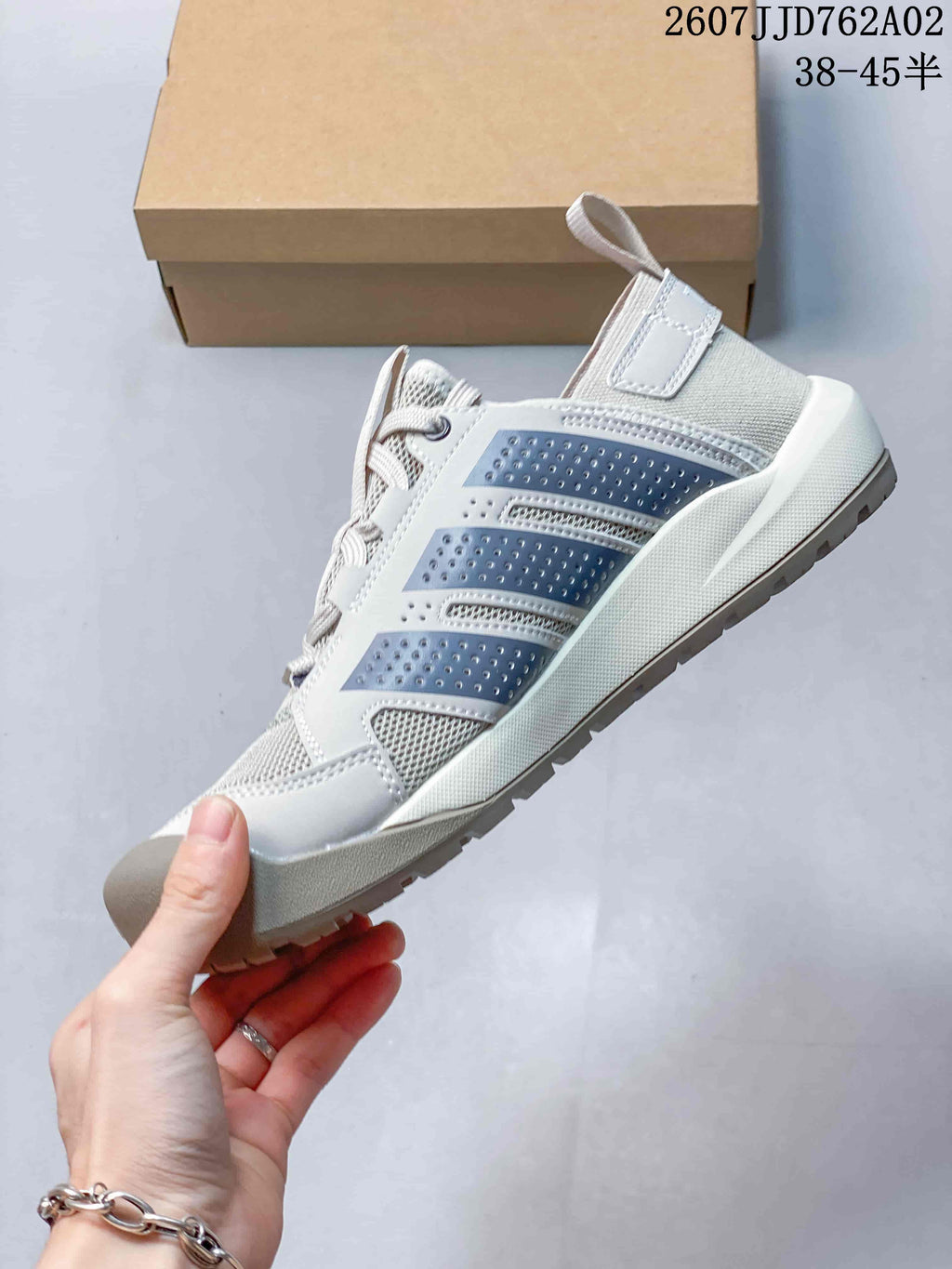 Side view of the light gray Terrex shoe with dark gray details and a treaded sole.