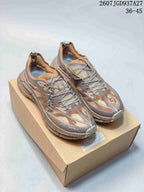 Pair of brown and taupe SATISFY sneakers displayed on a shoebox, with the TGD937A27 code and EU size range visible above.