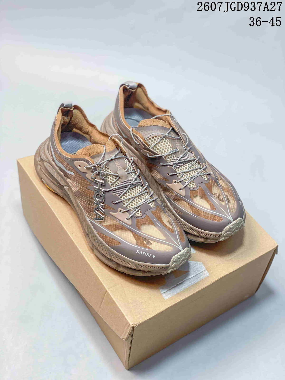 Pair of brown and taupe SATISFY sneakers displayed on a shoebox, with the TGD937A27 code and EU size range visible above.
