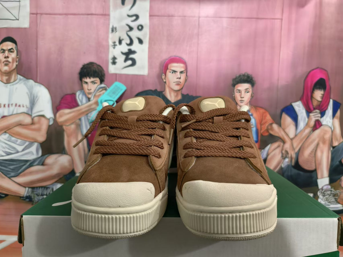 Front view of brown PUMA sneakers with brown laces and cream-colored toe and sole details