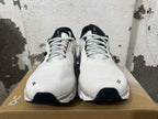 Front view of white On Running sneakers with black-and-white laces and black accents