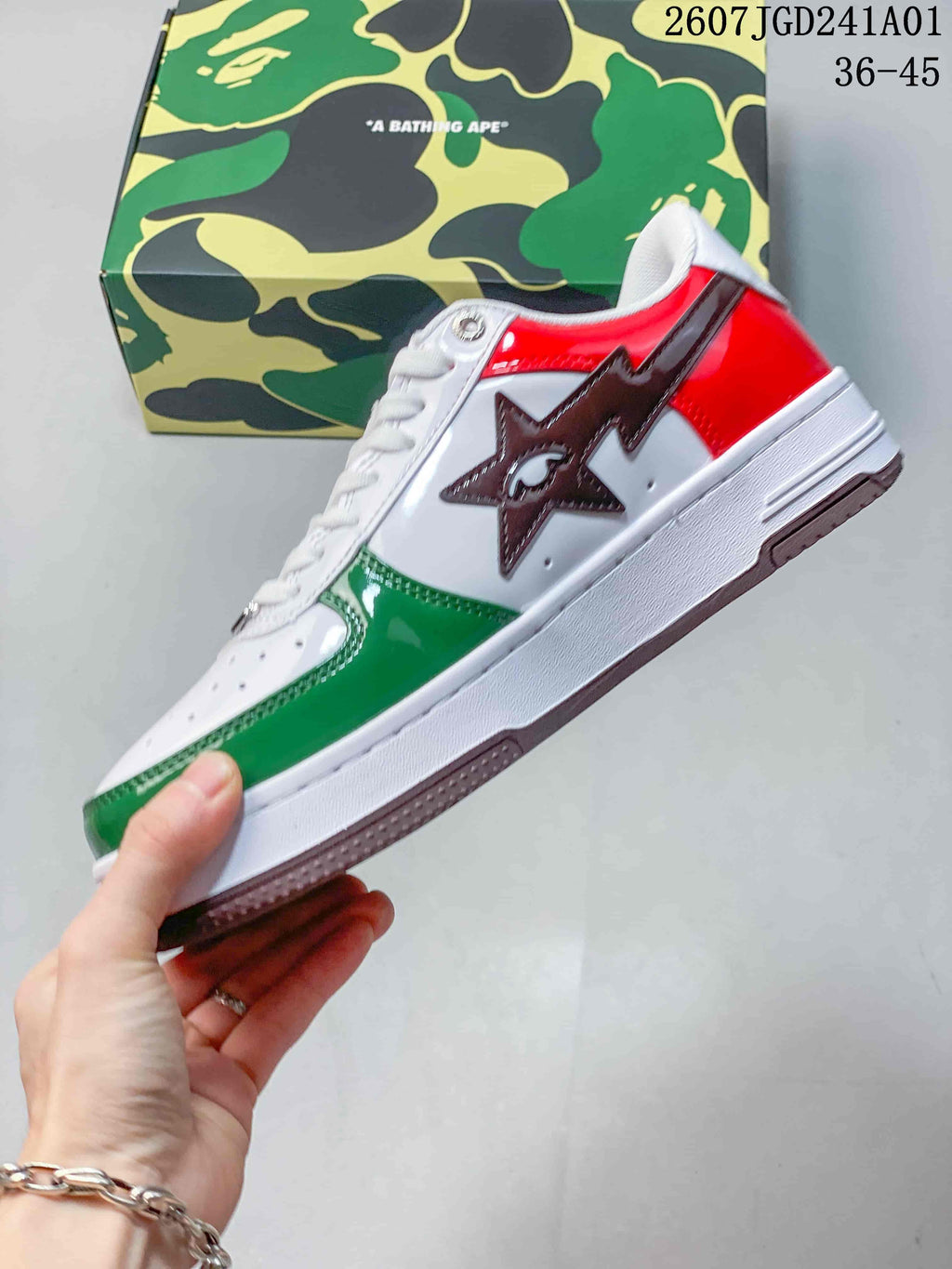 Side view of a white sneaker with green and red panels and a star-shaped detail
