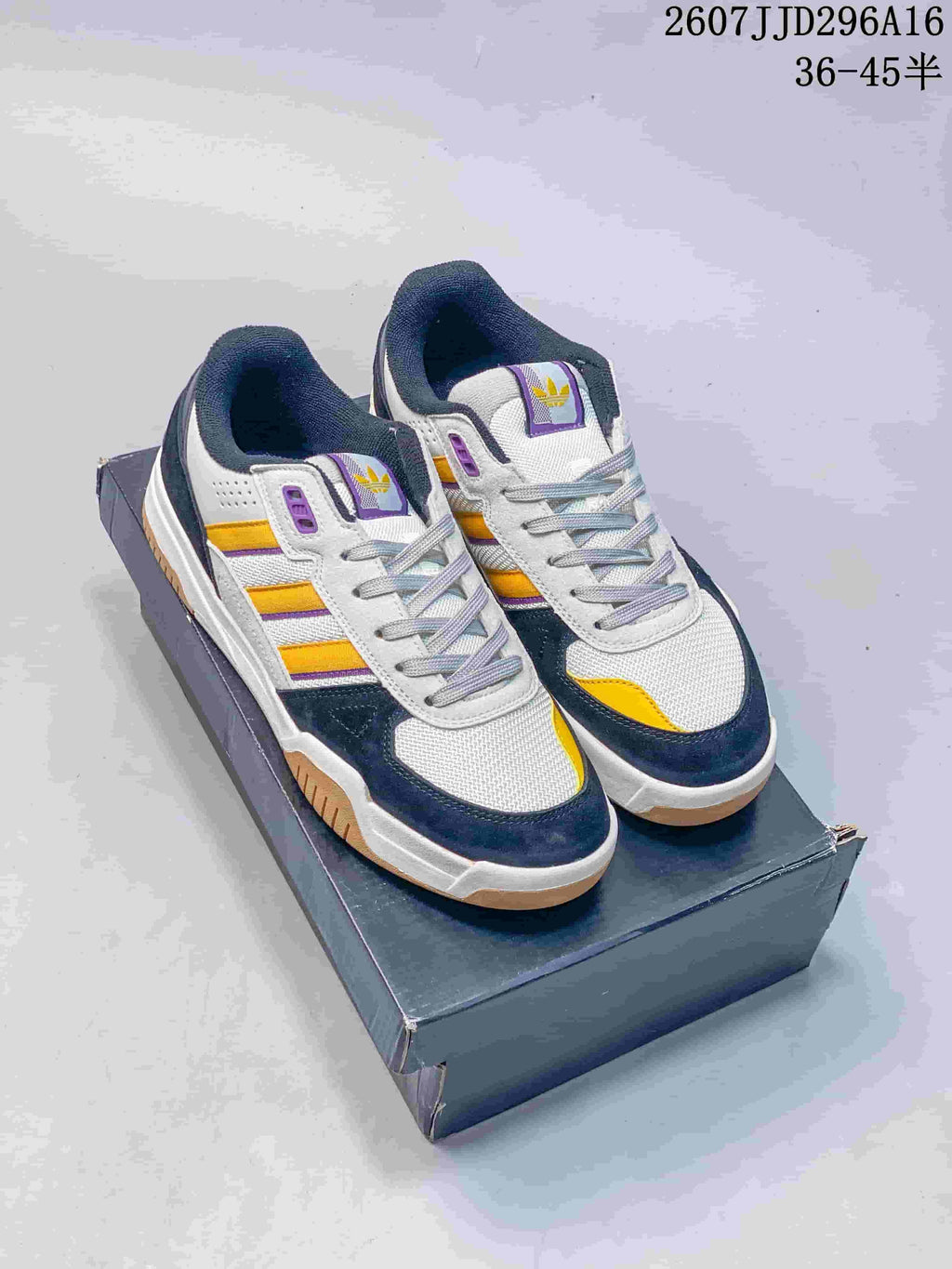 Pair of adidas Tekkira Cup sneakers on a shoebox, showing the white, navy, yellow and purple color scheme; overlay text shows style code 2607JJD296A16 and sizes 36–45.