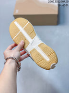 Underside view of the sneaker showing the gum-colored segmented outsole and textured tread pattern.