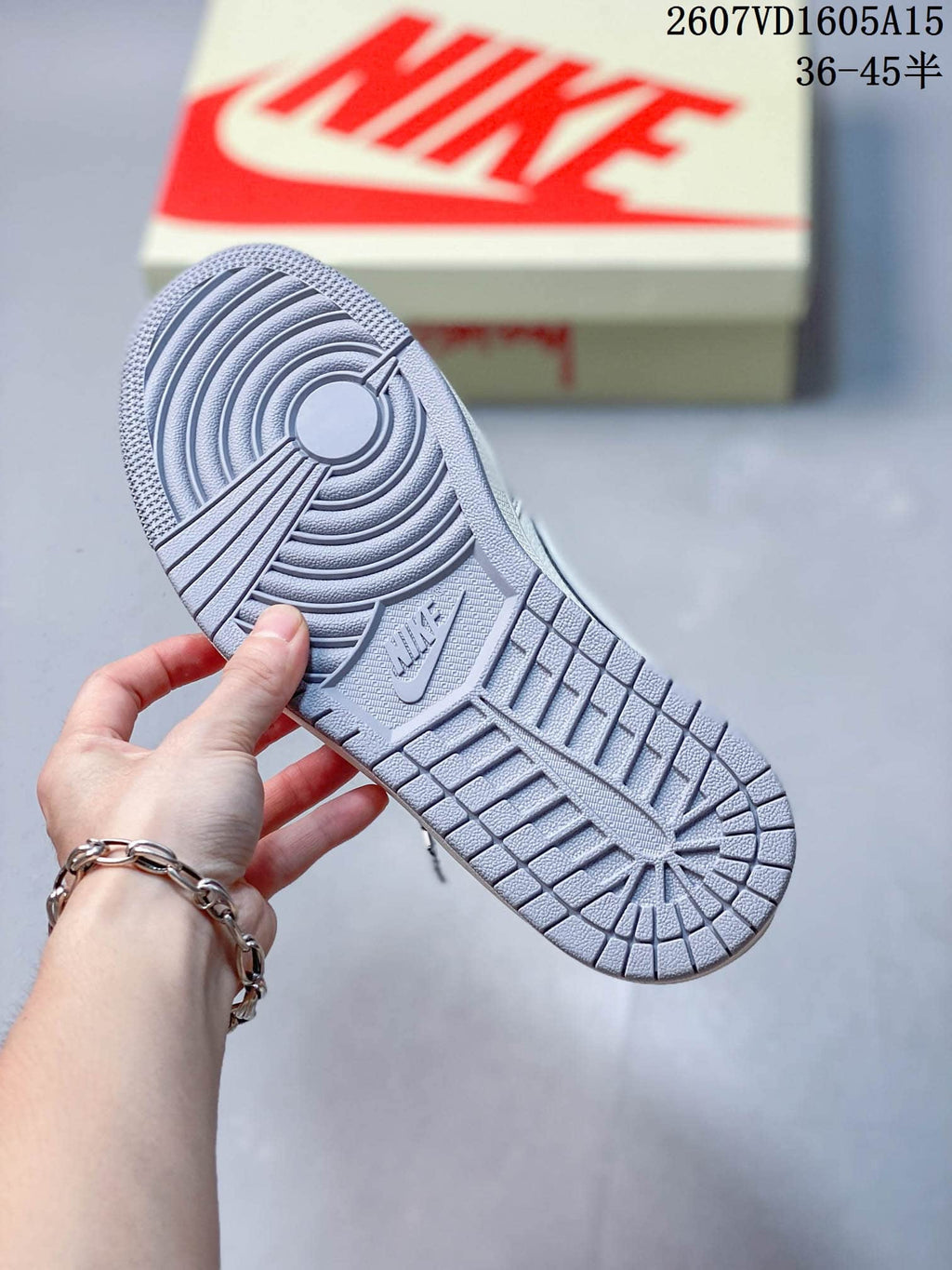 Bottom view showing the gray rubber outsole with circular traction grooves and geometric tread sections.