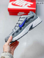 Side profile of the gray and blue Nike P-6000 showing mesh-style panels, overlays, and a textured sole.