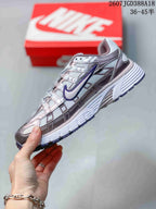 Side view of a white Nike P-6000 sneaker with metallic-looking overlays, purple Swoosh detailing and a textured sole.