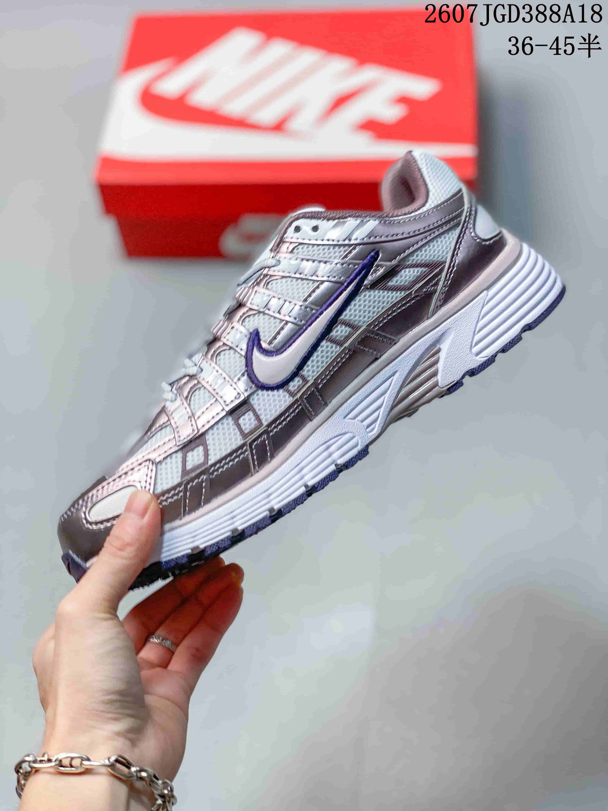 Side view of a white Nike P-6000 sneaker with metallic-looking overlays, purple Swoosh detailing and a textured sole.