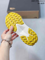 Close view of the yellow lugged outsole and white midfoot section, showing the shoe tread pattern.