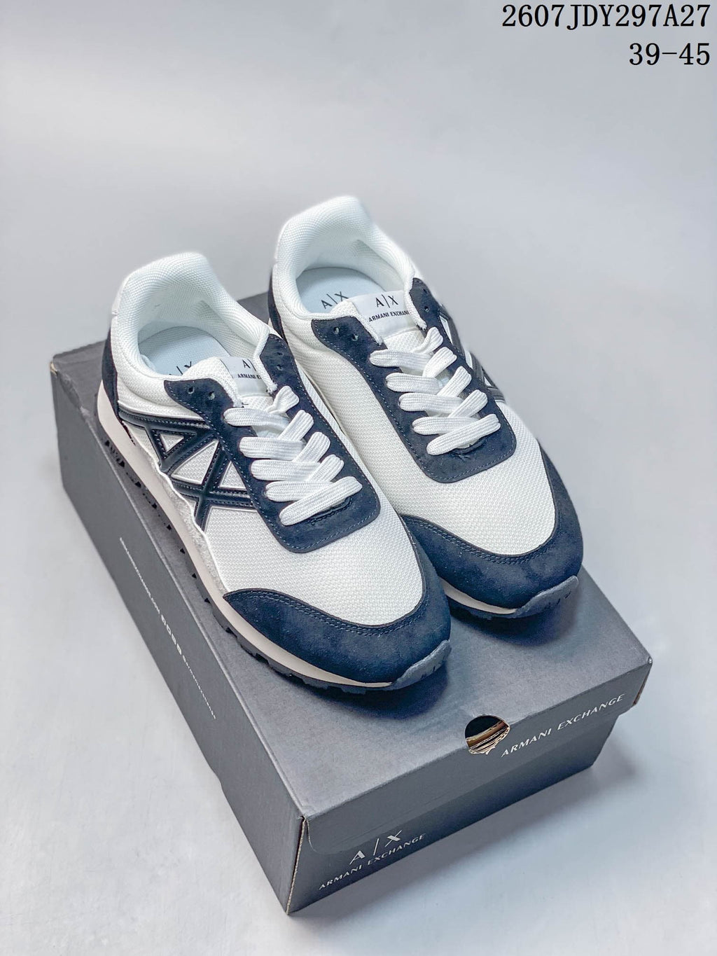 Pair of white and navy Armani Exchange low-top sneakers displayed on a branded shoe box.
