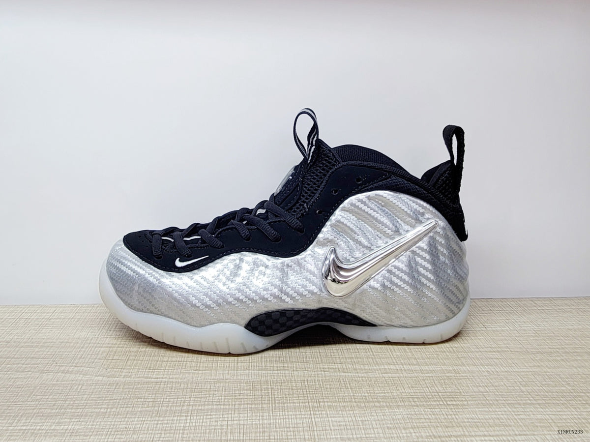 Side view highlighting the metallic-look Swoosh on a silver Nike Foamposite Pro