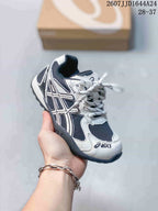Angled side view of an ASICS HYPERSYNC kids’ sneaker in white, navy and black with visible side branding and style code.