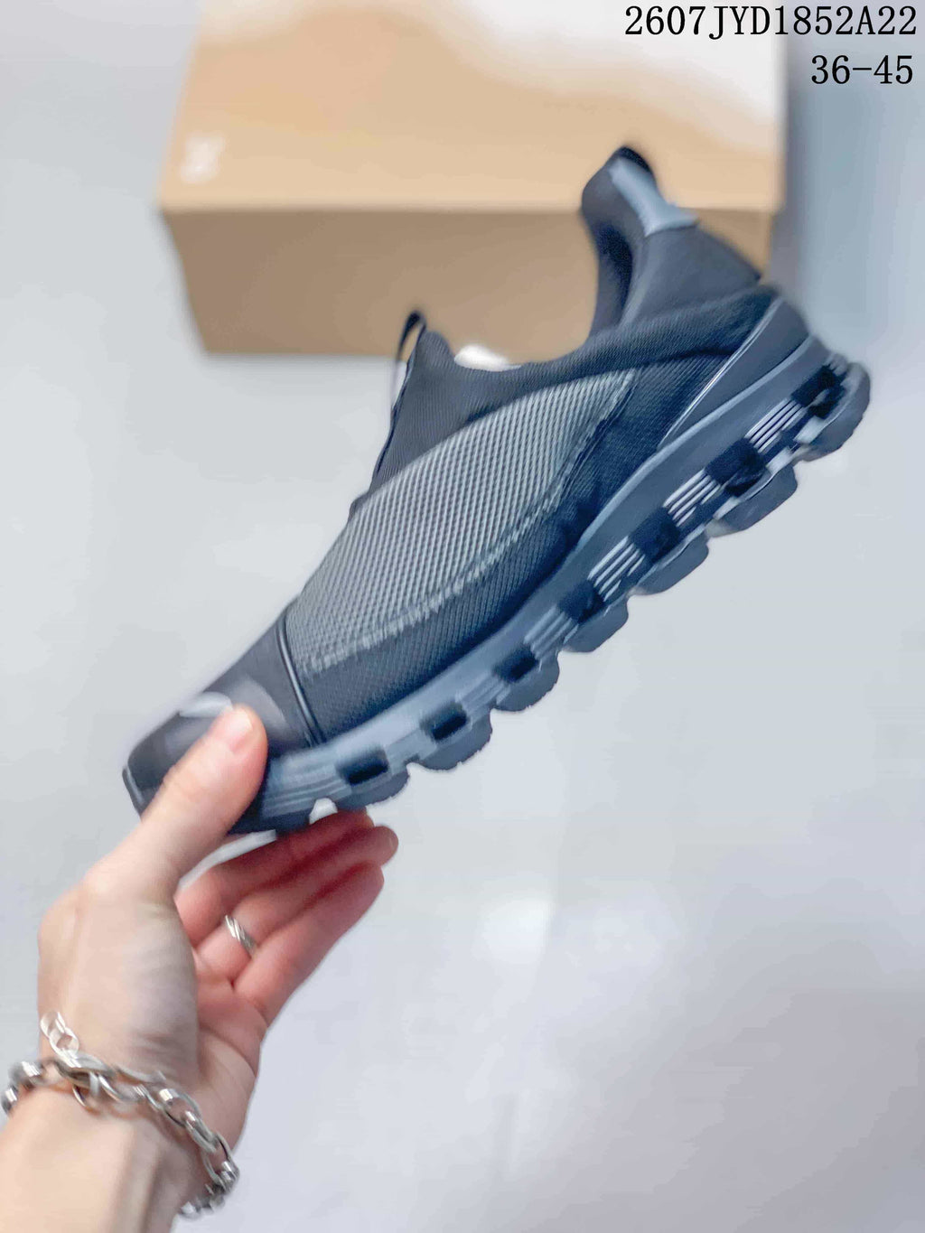 Side view of a black On sneaker showing the mesh side panel, layered upper and segmented outsole.
