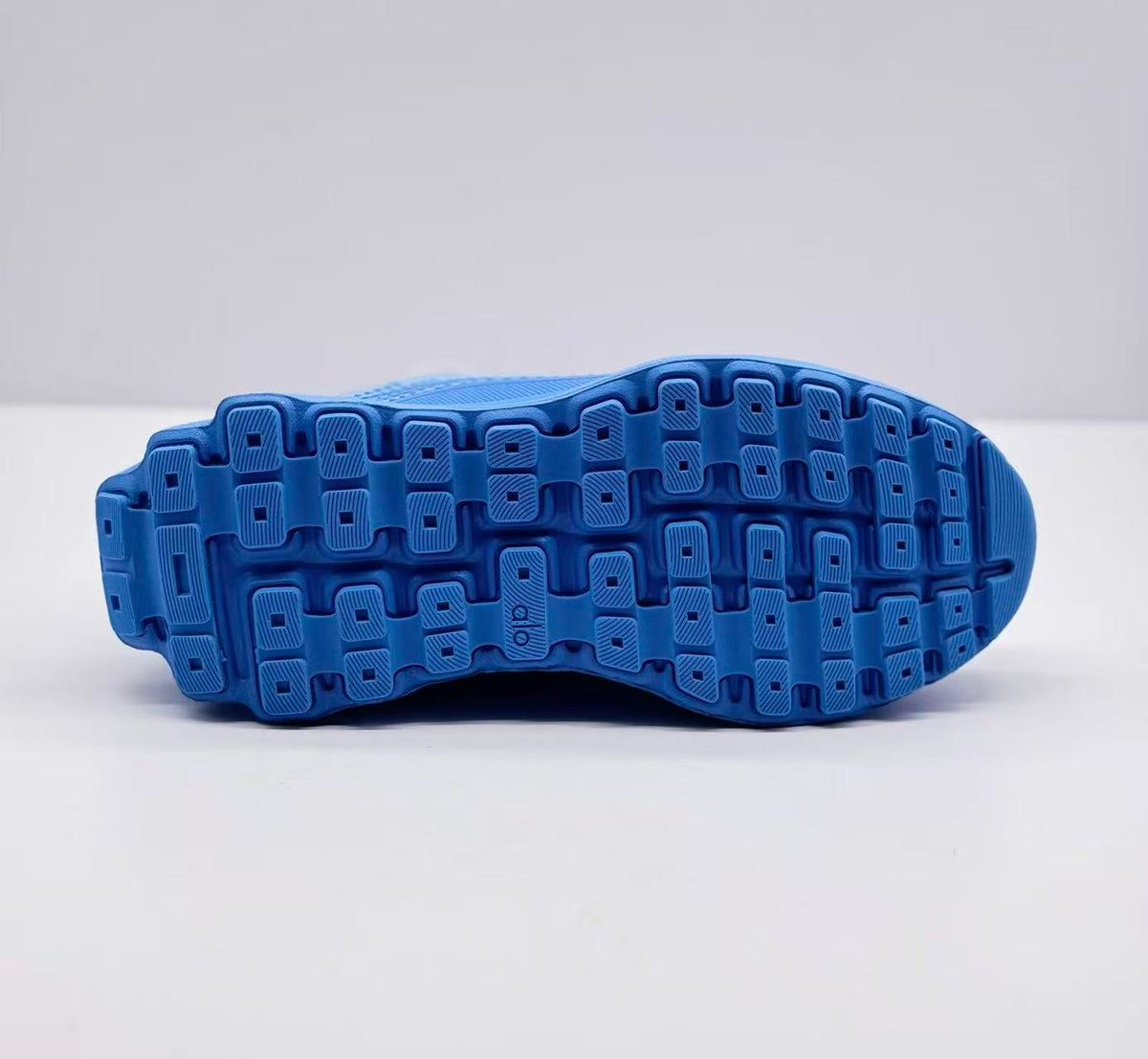 Underside view showing the blue outsole with a segmented tread pattern.