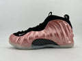 Side view of a high-top sneaker with a metallic pink sculpted exterior, black upper, checkerboard-patterned midfoot panel, and translucent-looking outsole