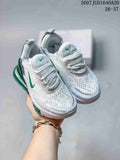 Pair of white and green Nike Air Max 270 kids' sneakers held against a light background.