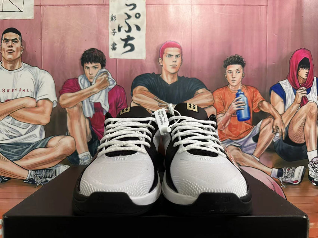 Front view of a pair of white and black basketball shoes with white laces