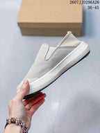 Side view showing the low-profile slip-on shape, textured upper, white midsole, and black outsole.