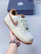 Angled side view showing the cream and white upper, brown Swoosh, padded collar, and gum outsole.