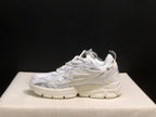Side profile of a white sneaker showing the layered side design, padded heel, and segmented outsole.
