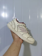 Angled view of the off-white and red Balenciaga Hamptons sneaker showing the layered upper, side logo and lace-up front.