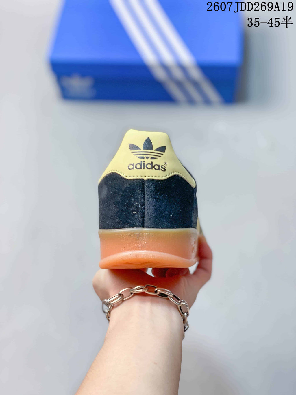 Rear view of the sneaker showing the Adidas trefoil heel detail and gum-colored heel section.
