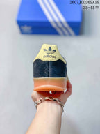 Rear view of the sneaker showing the Adidas trefoil heel detail and gum-colored heel section.