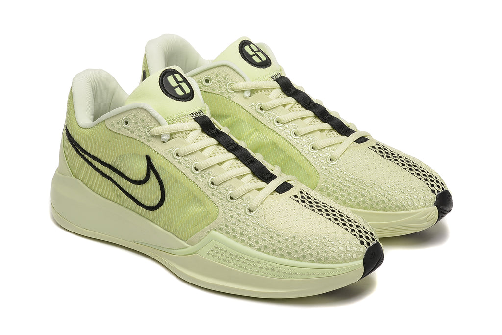 Pair of pale yellow-green Nike Sabrina 10 shoes in a three-quarter view