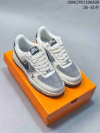 Pair of white-and-gray low-top sneakers with white laces on an orange box