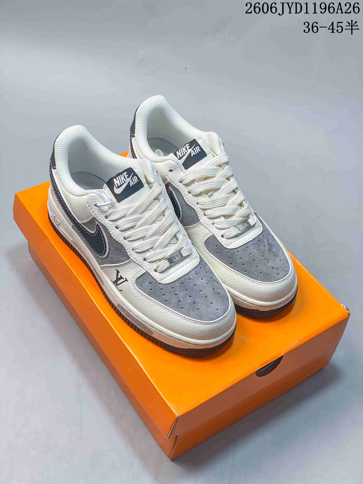 Pair of white-and-gray low-top sneakers with white laces on an orange box