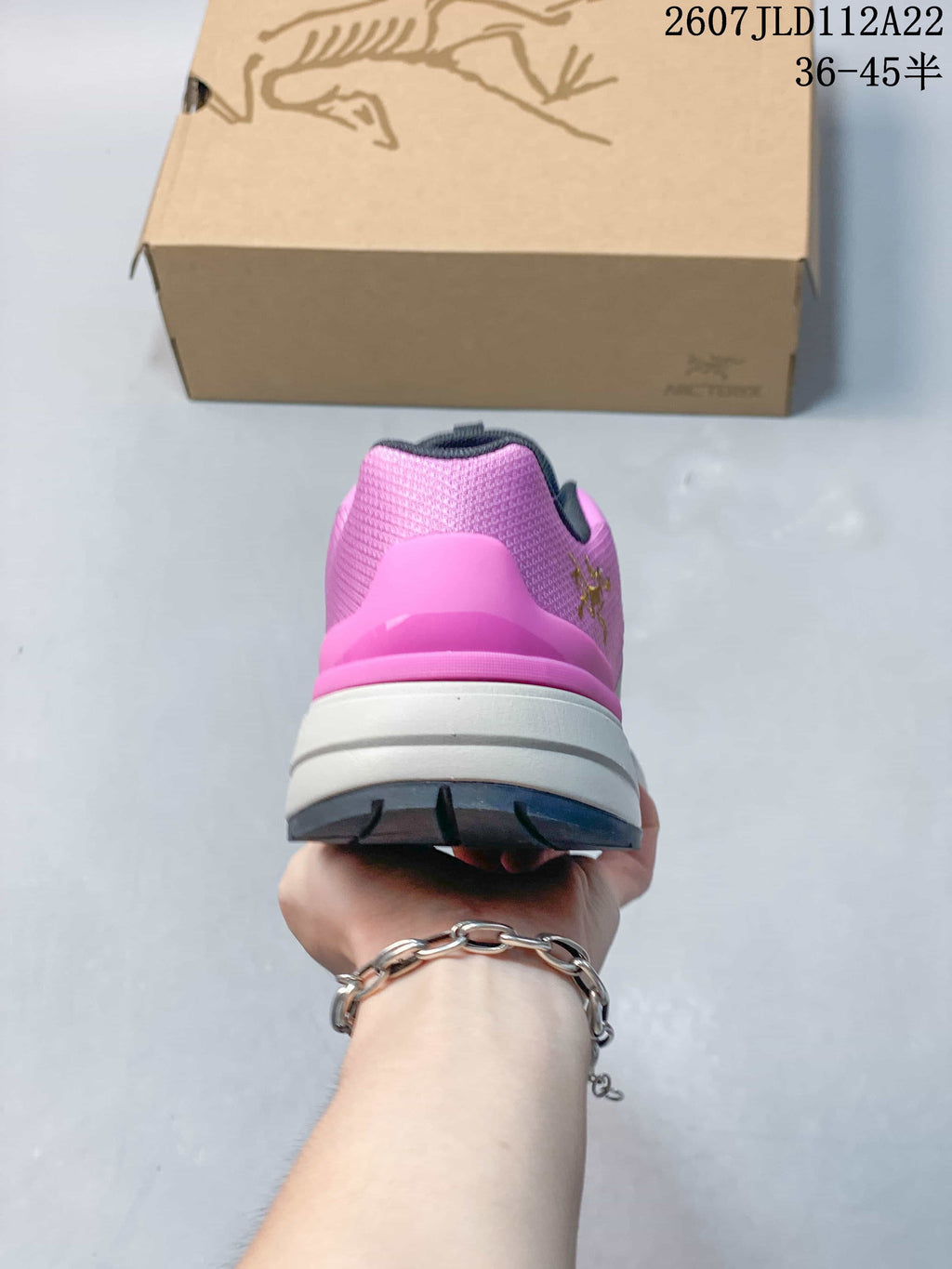 Rear view of the pink hiking shoe showing the padded heel structure, white midsole and dark outsole.