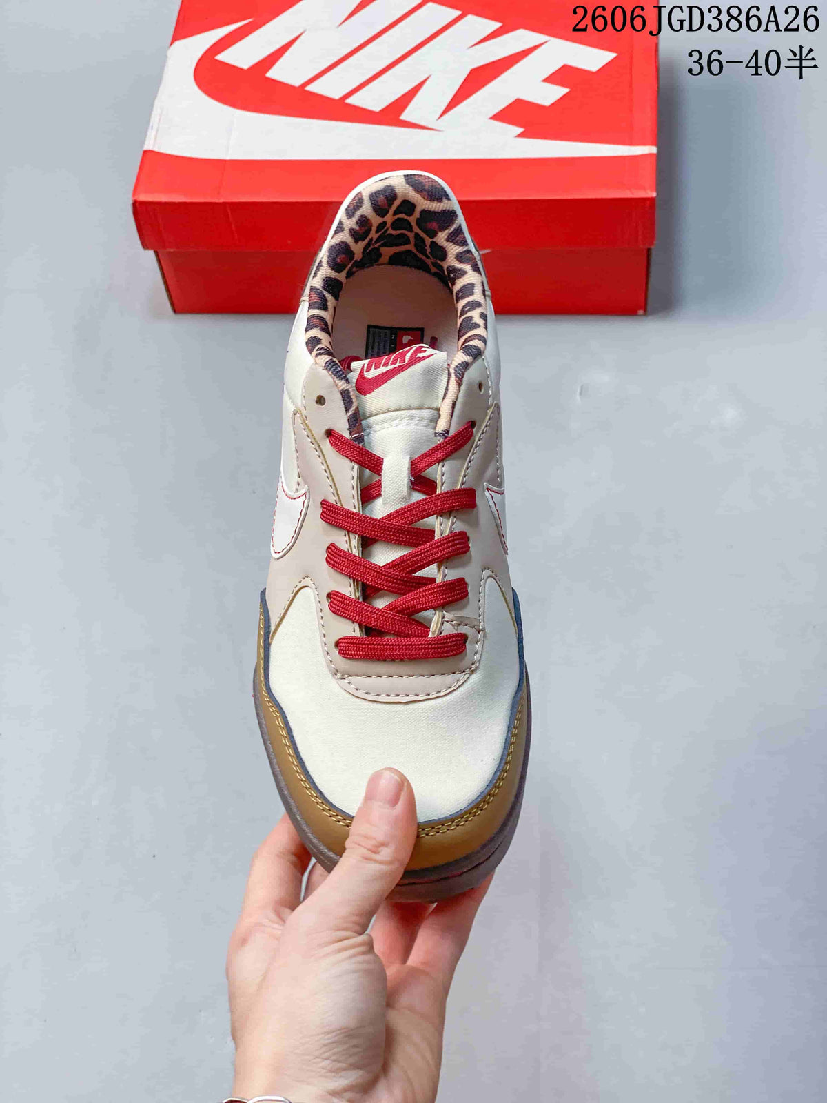 Top view of one sneaker showing red laces, cream panels, tan toe trim and leopard-print collar lining.