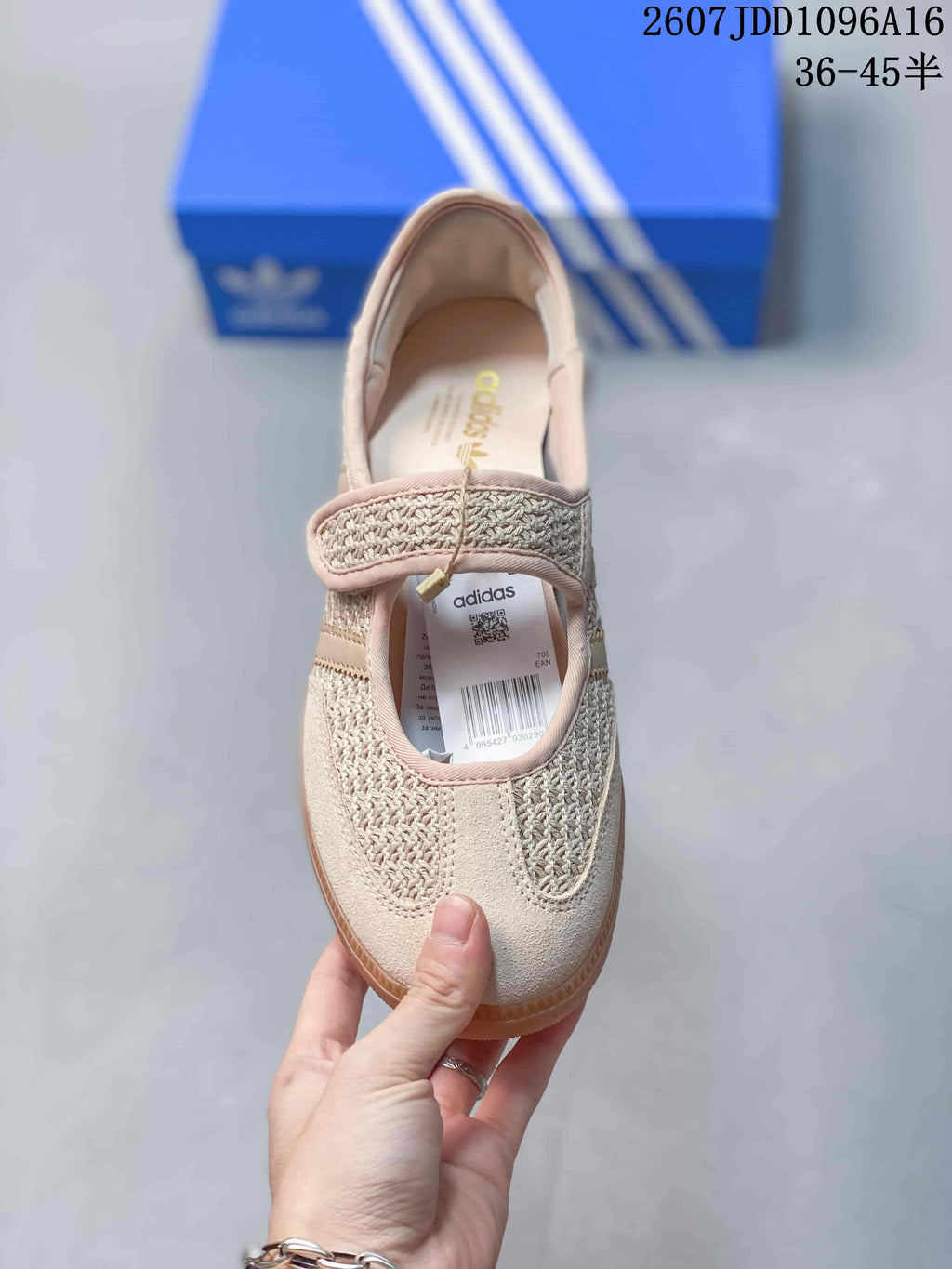 Top view of one beige sneaker showing the strap closure, woven-texture panels, Adidas insole branding, and product label.