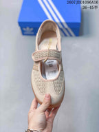 Top view of one beige sneaker showing the strap closure, woven-texture panels, Adidas insole branding, and product label.