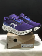 Purple and blue On Cloudmonster 3 running shoes displayed on their shoe box, with the box label visible.