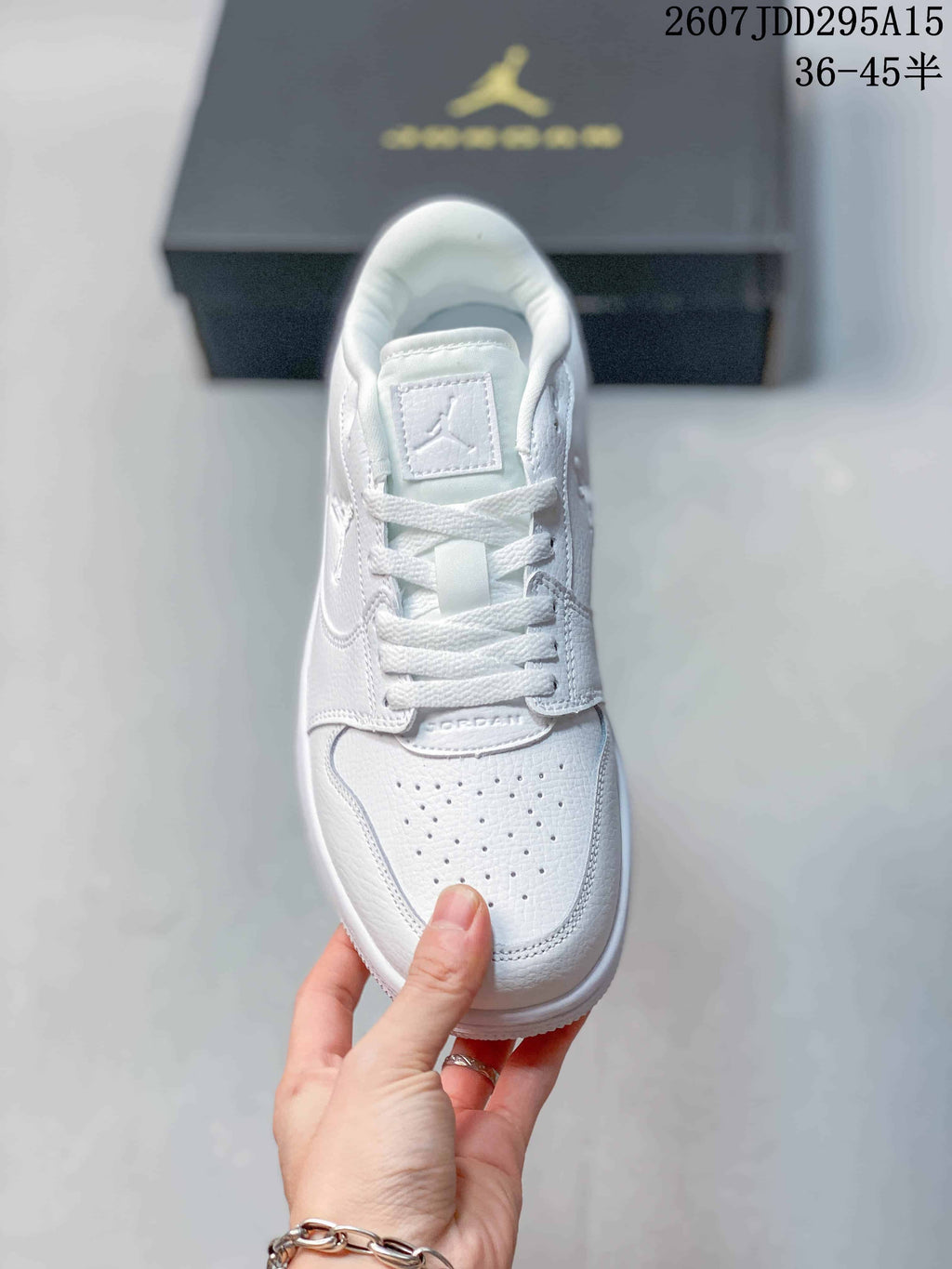 Top view of the white sneaker showing the tongue label, white laces and perforated toe panel.