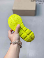 Close-up of the bright lime outsole showing segmented construction and textured tread.