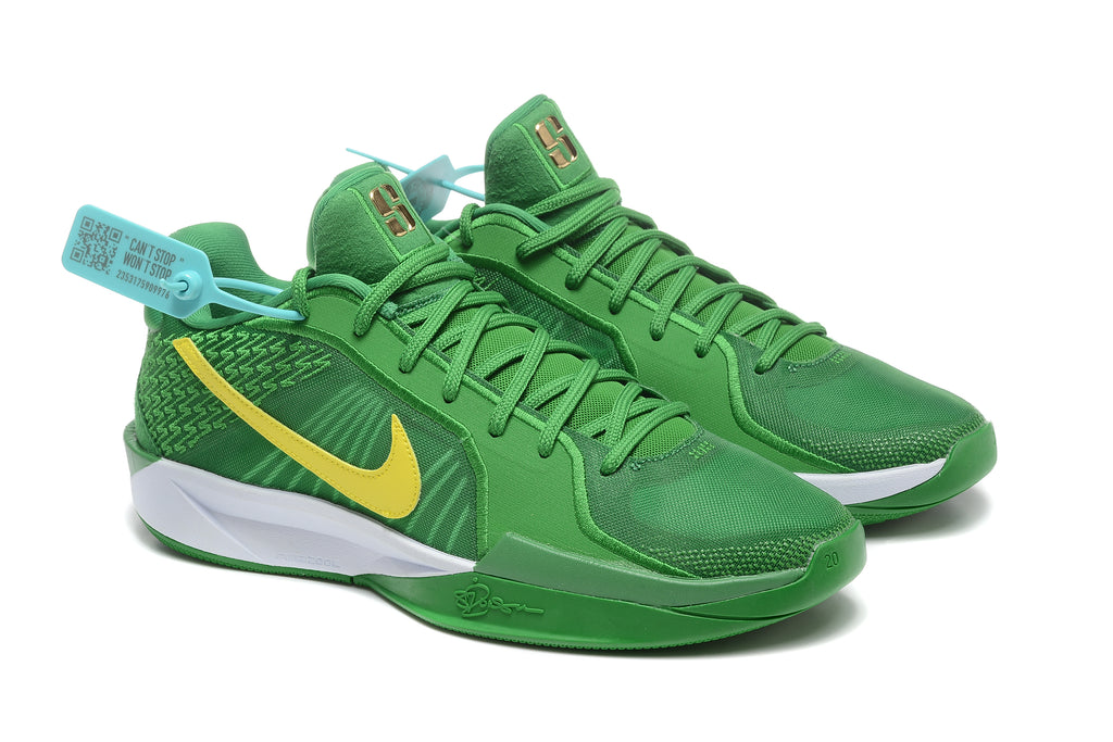 Angled view of a pair of green Nike Sabrina 2 shoes with yellow Swooshes and green laces.