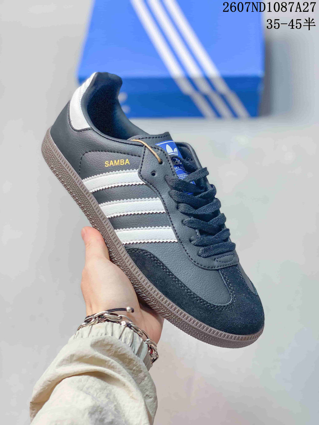 Angled side view showing Samba branding, white three-stripe panels, black upper and gum-colored outsole.