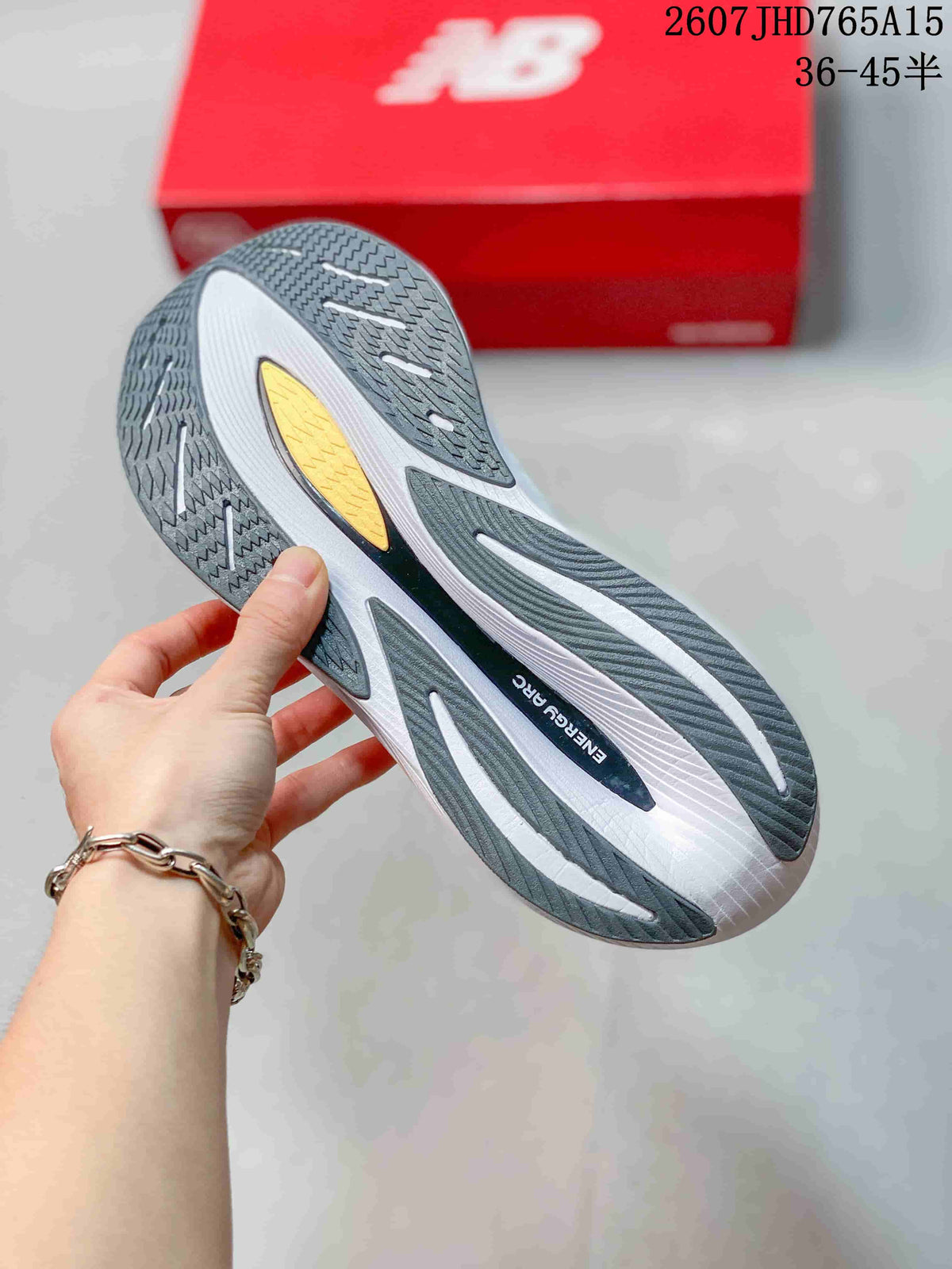 Close view of the shoe outsole showing dark patterned rubber sections, white grooves, and a yellow insert.