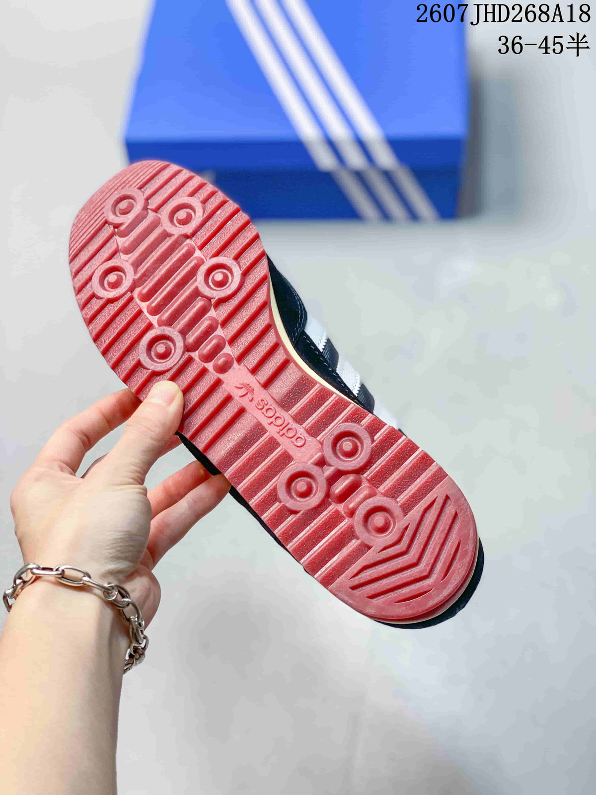 Close view of the burgundy rubber outsole with textured grooves and circular traction details.