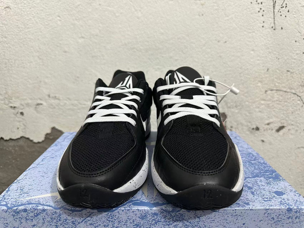 Front view of black basketball shoes with white laces and tongue logos