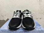 Front view of black basketball shoes with white laces and tongue logos