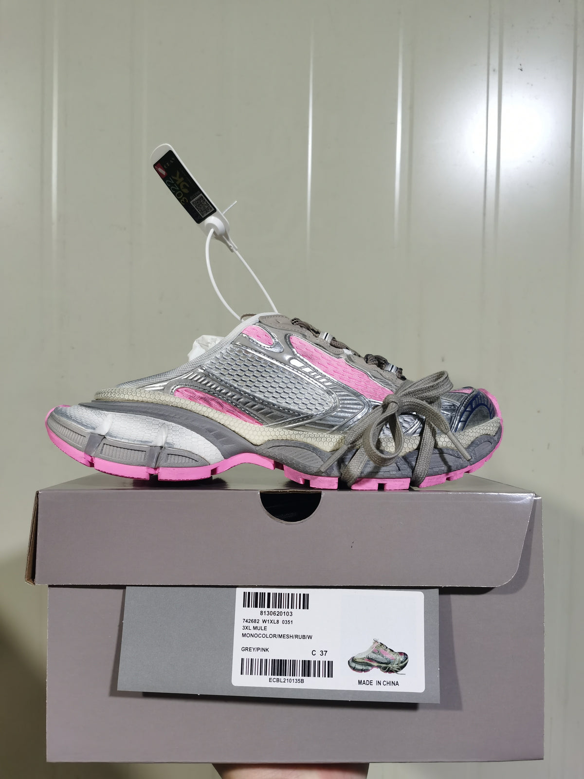 Grey and pink layered sneaker displayed on its box, with a visible box label showing 3XL MULO, GREY/PINK, and C 37.