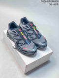 Pair of gray Salomon XT-6 shoes with quick laces and colored accents, shown on a shoe box