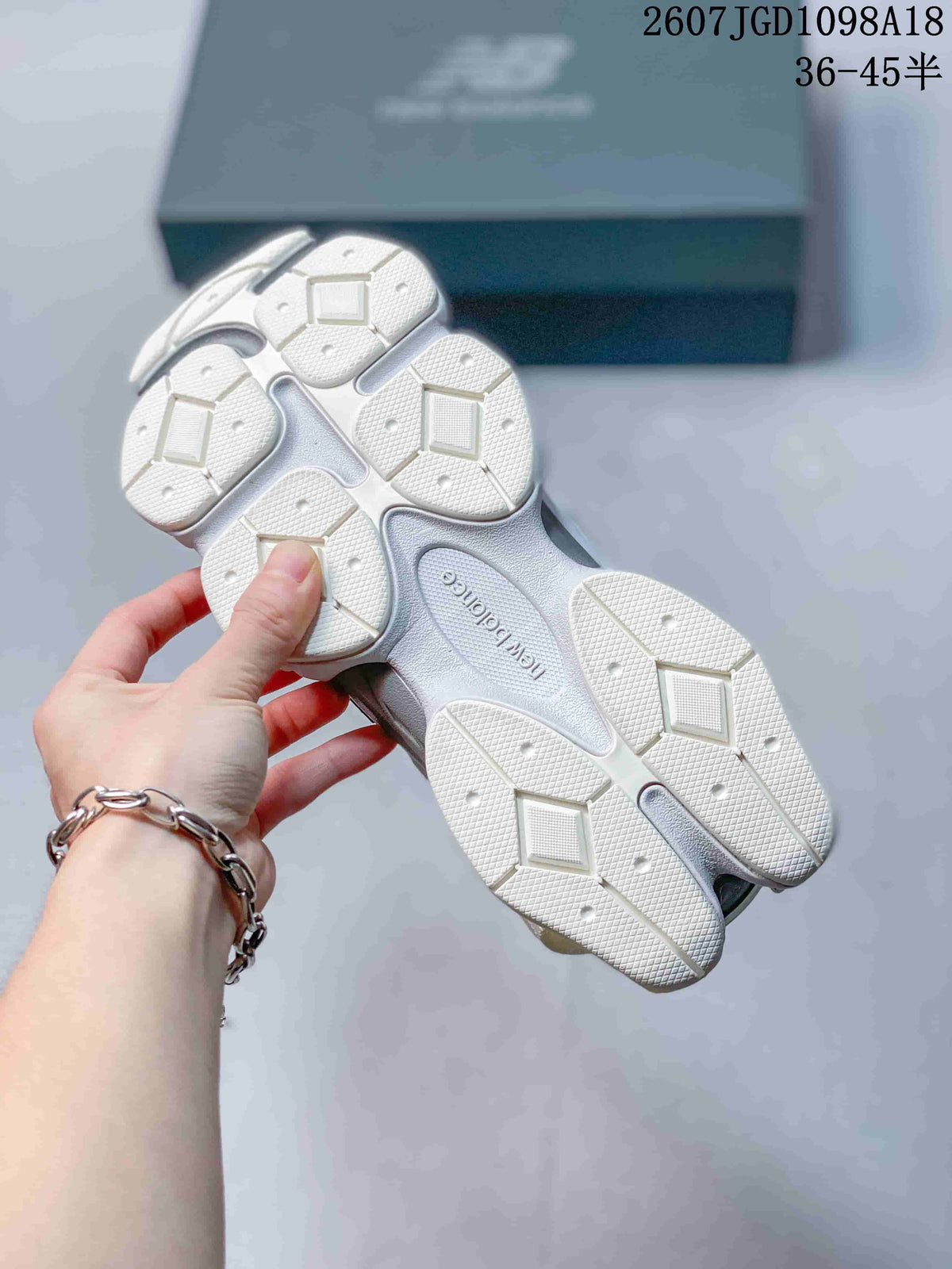Underside view of the New Balance 9060 sneakers showing the segmented white and grey outsole with geometric tread blocks.